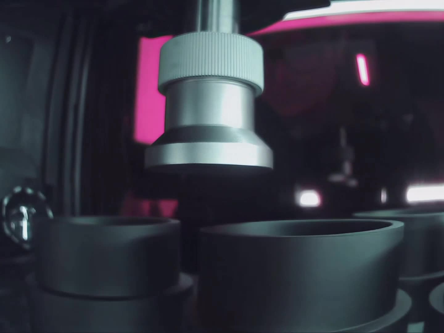 Close-up of the material handling mechanism above a row of resin vats inside the printer.